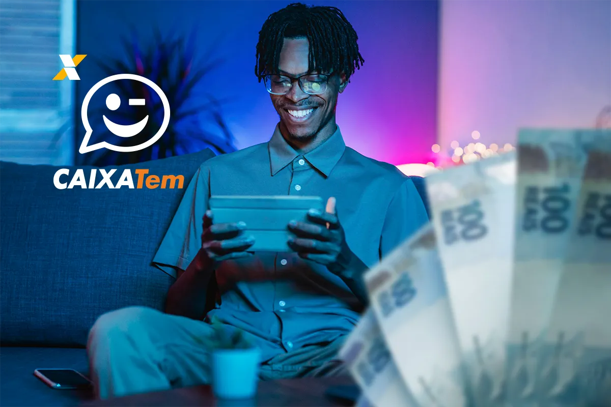 Homem sorrindo enquanto usa o aplicativo Caixa Tem no tablet com cédulas de R$ 100 ao fundo.