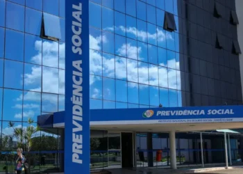 Fachada do prédio do INSS, com o logotipo e nome 'Previdência Social' visíveis, simbolizando a devolução de descontos indevidos aos beneficiários do INSS