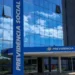 Fachada do prédio do INSS, com o logotipo e nome 'Previdência Social' visíveis, simbolizando a devolução de descontos indevidos aos beneficiários do INSS