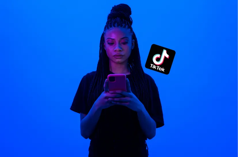 Mulher jovem utilizando o celular com o ícone do TikTok, representando oportunidades para ganhar dinheiro com aplicativos.