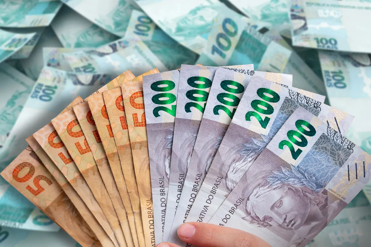 Notas de dinheiro, incluindo cédulas de 50 e 200 reais, representando o Auxílio Mãe Atípica.