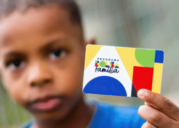 Cartão do Bolsa Família sendo mostrado por uma criança.