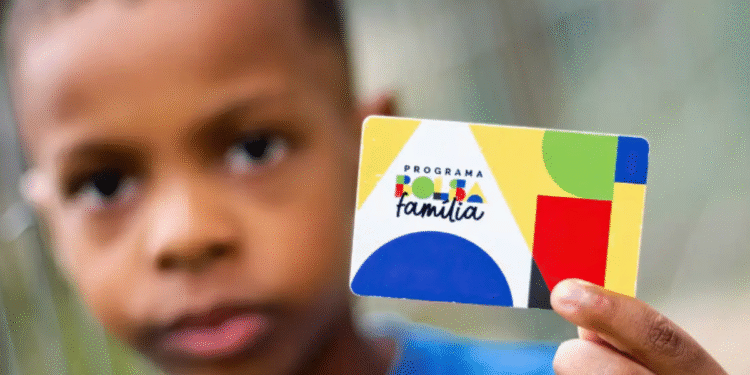 Cartão do Bolsa Família sendo mostrado por uma criança.