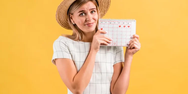Mulher segurando um calendário com marcas indicando feriados, destacando os feriados de julho de 2025.