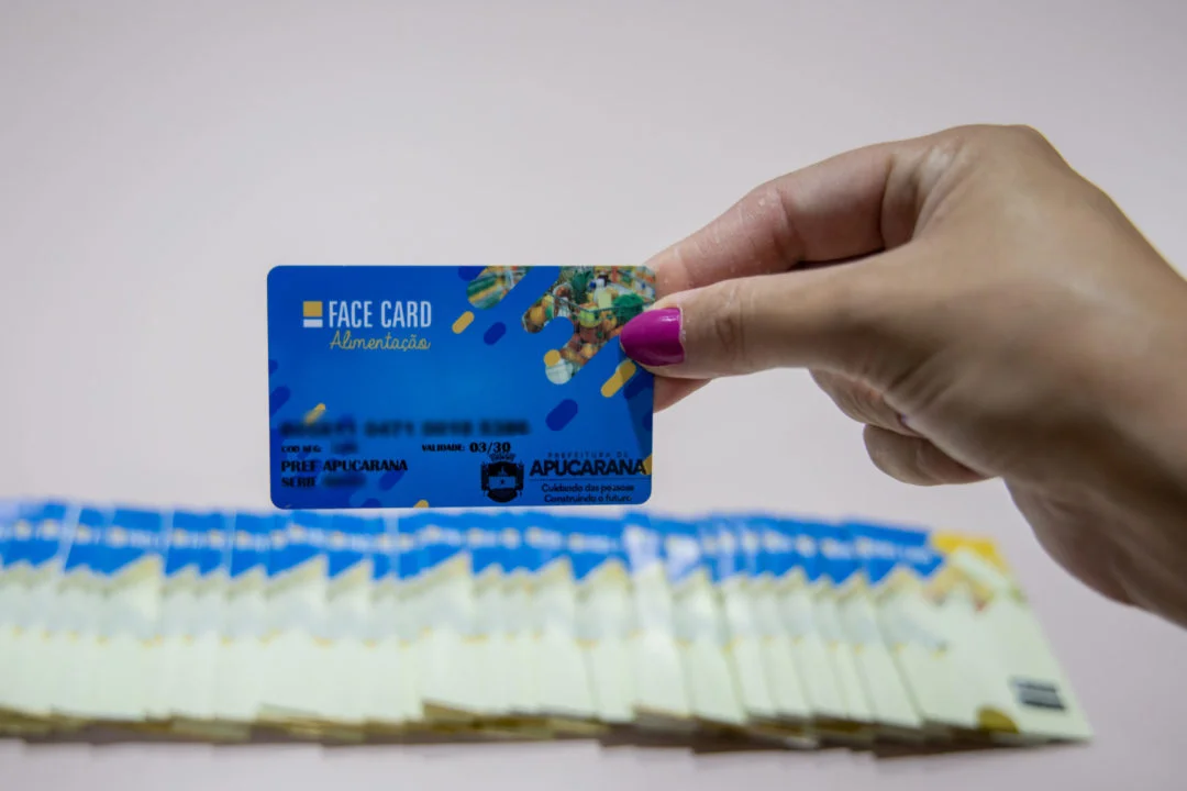 Cartão do Auxílio Alimentício de Apucarana, com a palavra 'FACE CARD' visível, com fundo azul e design colorido.