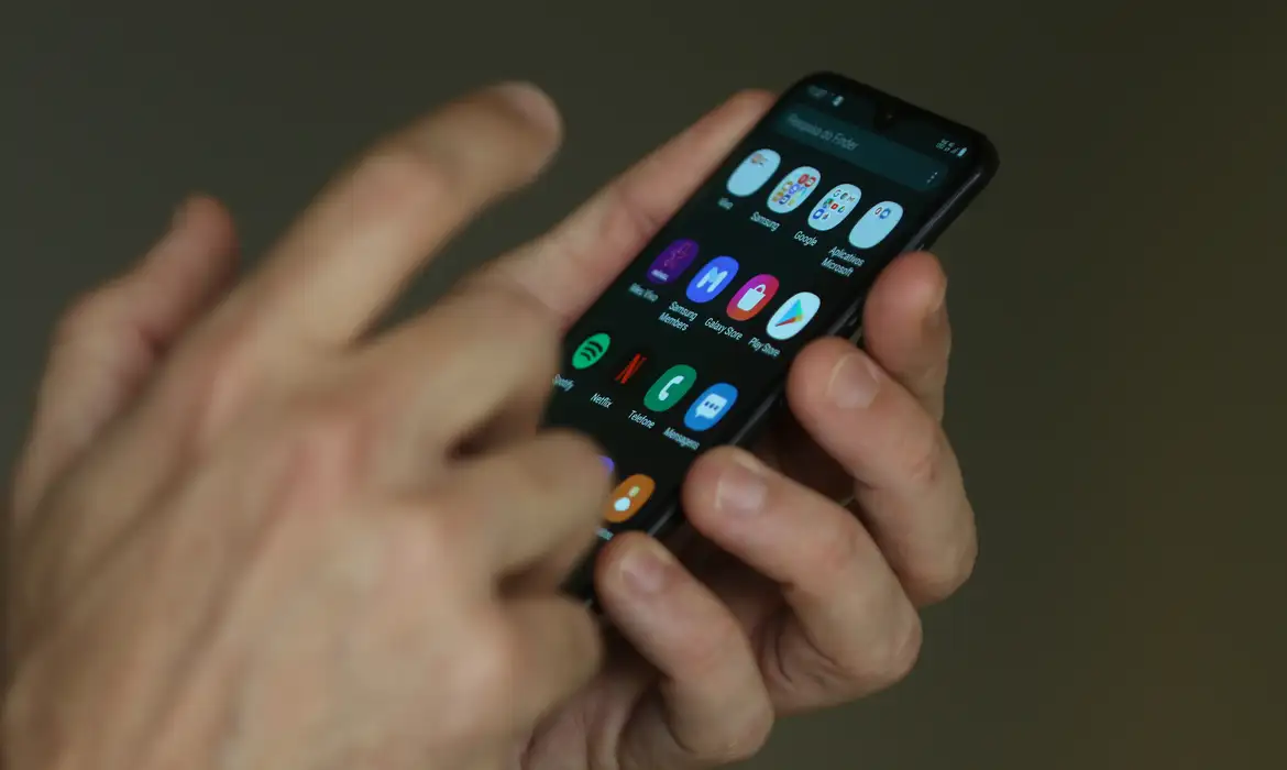 Pessoa utilizando celular para acessar serviços online