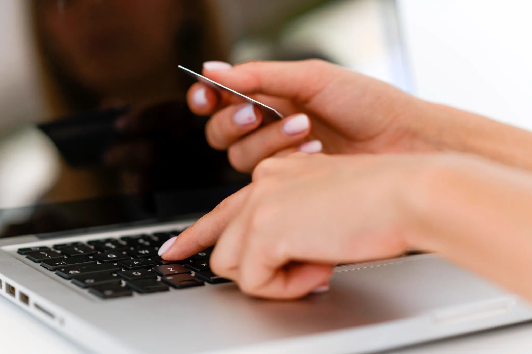 Mãos digitando em notebook com intuito de realizar a consulta de pagamentos do pé-de-meia