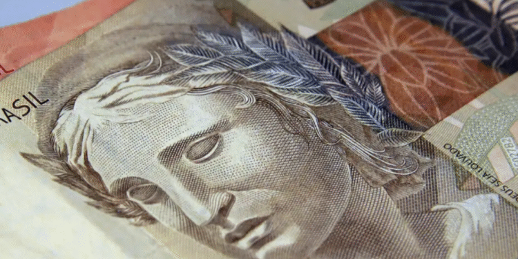 Nota de cinco reais, representando dinheiro brasileiro usado em transações financeiras, como na antecipação de salário.