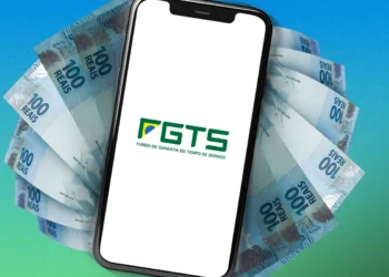 Celular com logotipo do FGTS sobre cédulas de cem reais