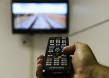 Controle remoto apontando para uma TV com sinal da parabólica digital