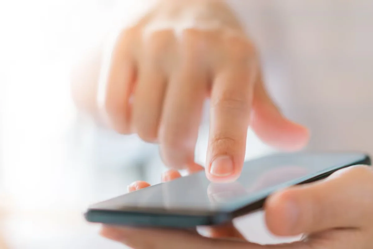 Pessoa interagindo com smartphone para solicitar kit parabólica digital do Programa Brasil Antenado