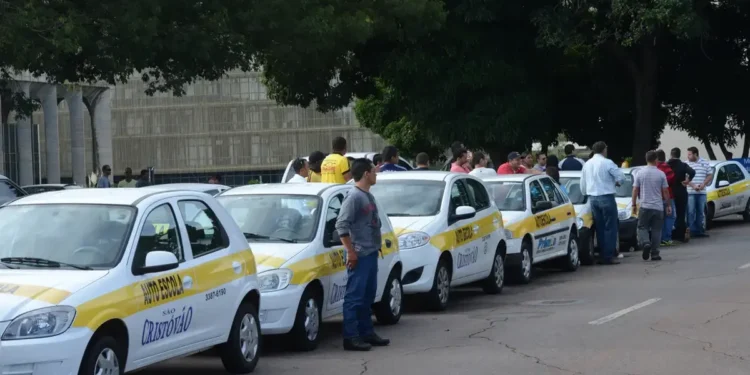 Carros de autoescola parados na rua, esperando alunos para aulas de direção.