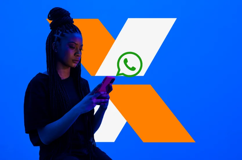 Pessoa usando o WhatsApp com logo da CAIXA ao fundo