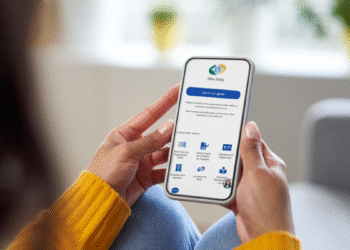 Pessoa acessando o aplicativo Meu INSS em um smartphone para consultar informações sobre pagamentos e benefícios.