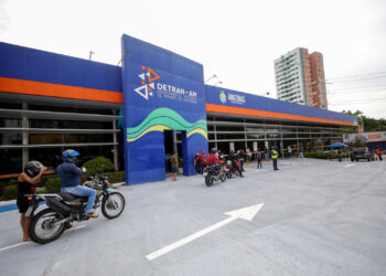 Fachada do Departamento Estadual de Trânsito do Amazonas (Detran-AM) com motociclistas aguardando atendimento, onde acontece o projeto CNH Social.