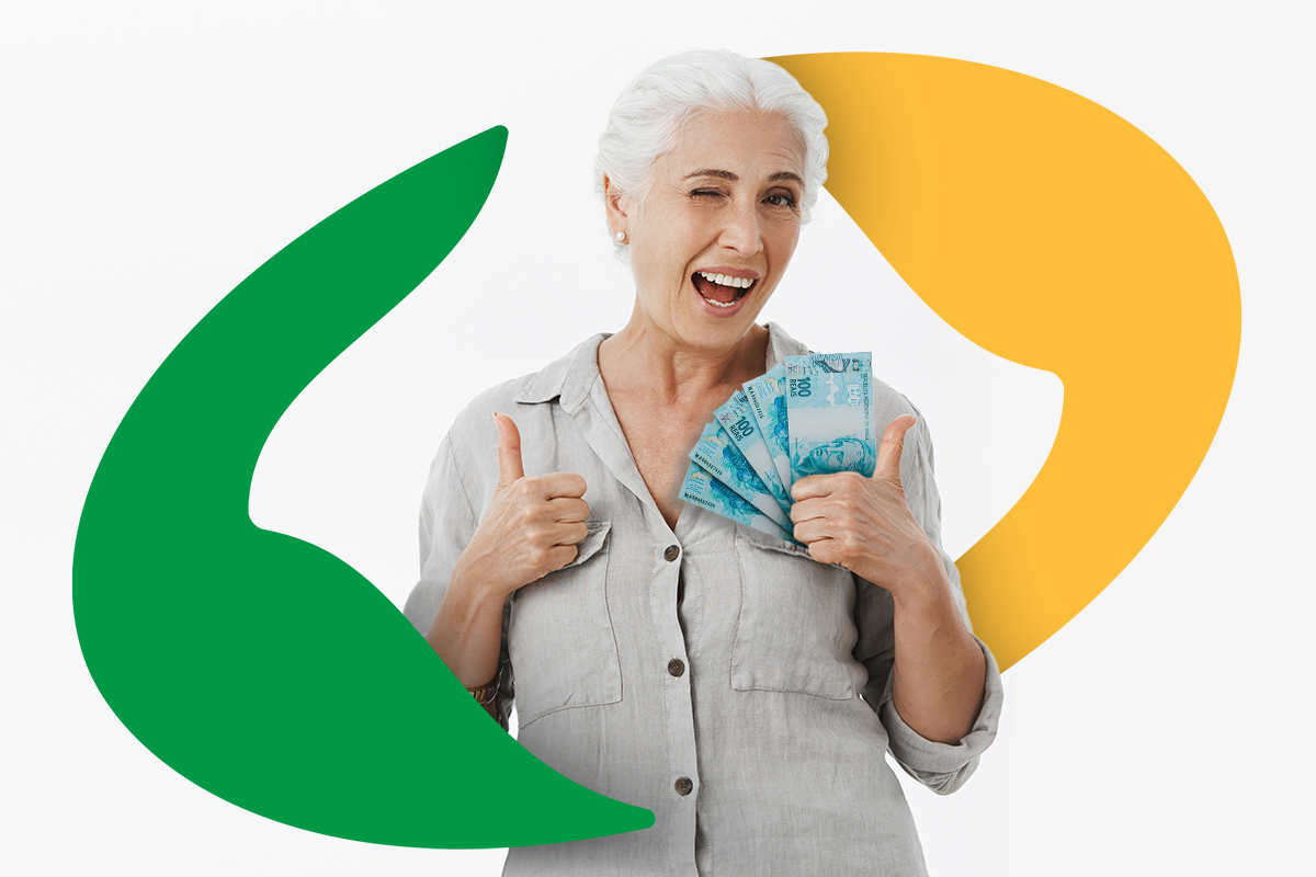 Idosa sorridente segurando notas de 100 reais e fazendo sinal de positivo