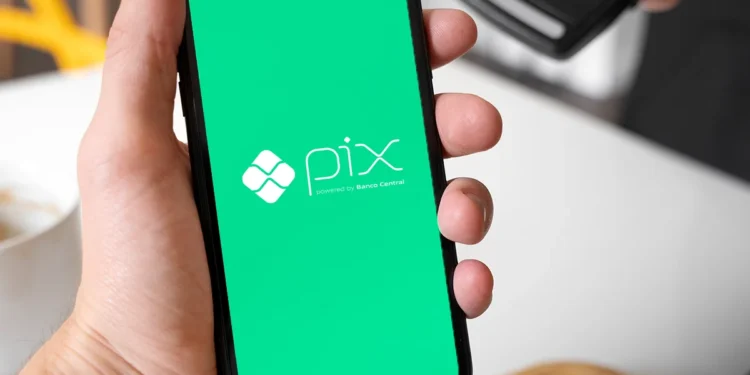 Pessoa usando um smartphone com o logo do Pix, representando as mudanças que ocorrerão no sistema de pagamentos a partir de setembro de 2025.