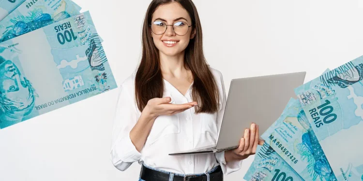 Mulher segurando notebook e mostrando dinheiro, ilustrando o benefício do abono salarial para quem trabalhou um mês em 2023