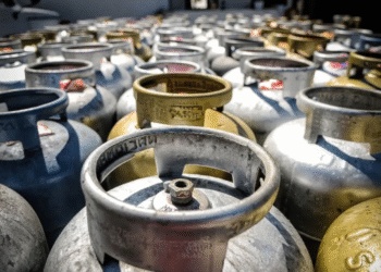 Imagem de vários cilindros de gás empilhados em um depósito, relacionados ao programa Gás do Povo.