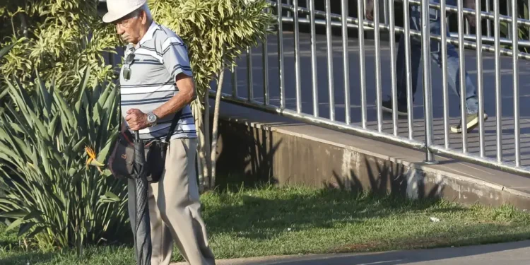 Idoso caminhando na rua, representando aposentados que precisam realizar a prova de vida em 2025.