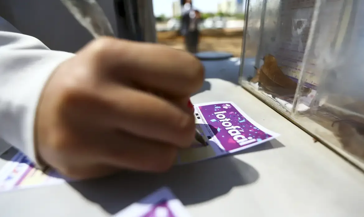 Pessoa preenchendo bilhete da Lotofácil da Independência 2025