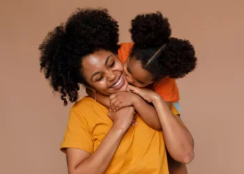 Mãe e filha sorrindo juntas em um momento de carinho, representando a relação entre as mães de Pernambuco e o novo pagamento de R$ 300.