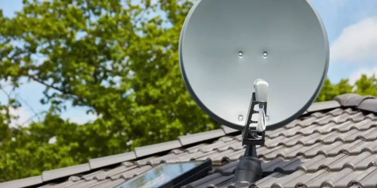 Antena digital instalada no telhado com painel solar, destacando a transição para a TV digital gratuita no Brasil.