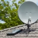 Antena digital instalada no telhado com painel solar, destacando a transição para a TV digital gratuita no Brasil.