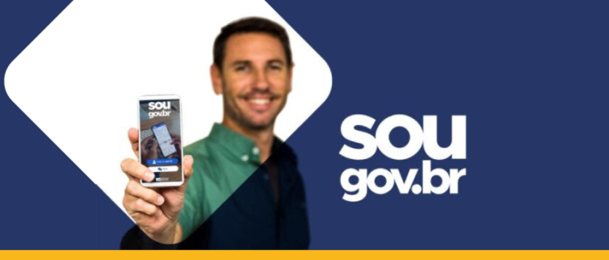 Homem sorrindo segurando um smartphone que exibe o aplicativo SOUGOV.BR, indicando o canal oficial para a solicitação de benefícios federais.