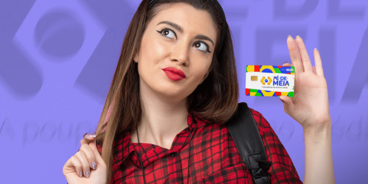 Jovem segurando cartão Pé de Meia com fundo roxo e texto desfocado