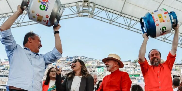 Representantes do governo comemoram o lançamento do programa Gás do Povo com botijões simbólicos erguidos.
