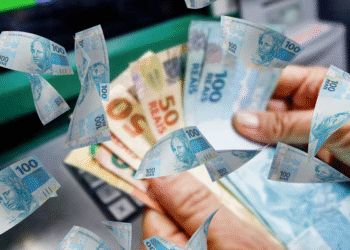 Pessoas recebendo notas de 100 e 50 reais, representando os pagamentos que a Caixa Econômica Federal irá liberar em setembro.