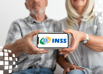Casal de idosos segurando um smartphone com o logo do INSS, representando a prova de vida digital e o acesso aos serviços do instituto.
