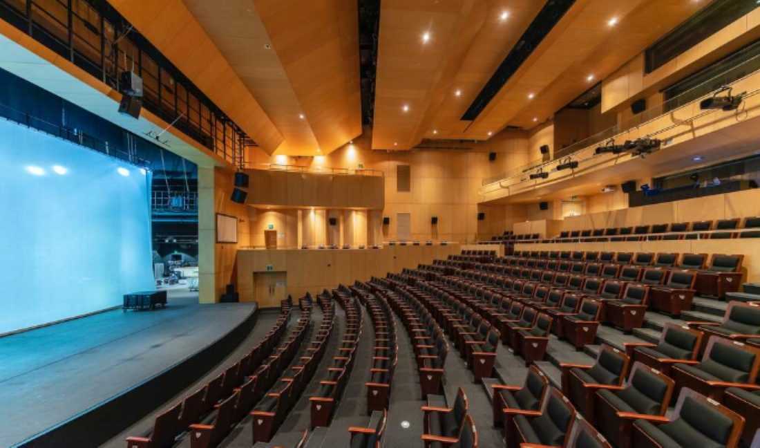 Auditório com cadeiras organizadas representando espaço para evento de professores