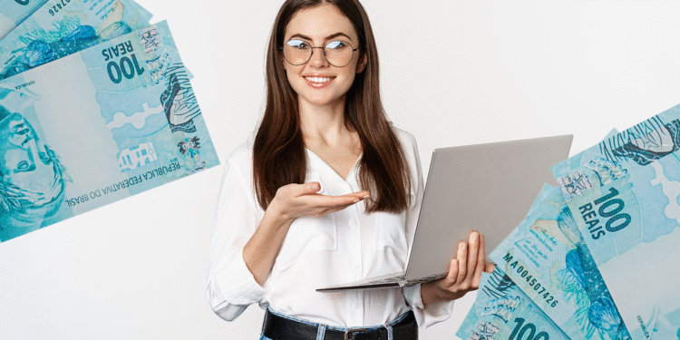 Mulher sorridente apresenta laptop e notas de 100 reais, simbolizando o recebimento do 13º salário.