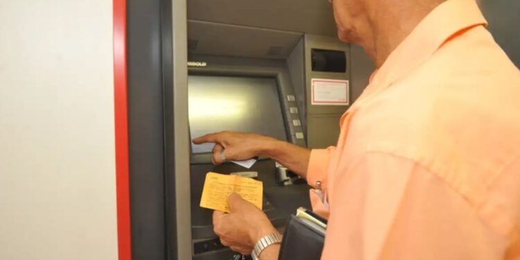 Pessoa utilizando um caixa eletrônico para consultar o extrato, simbolizando a necessidade de acompanhar as movimentações financeiras.