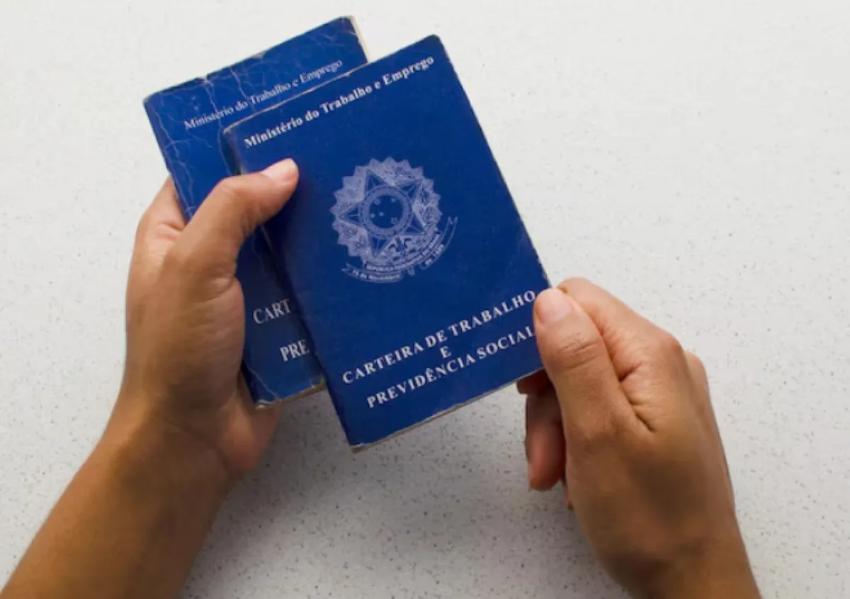 Carteiras de trabalho sendo analisadas no contexto de decisão sobre desligamento e benefícios