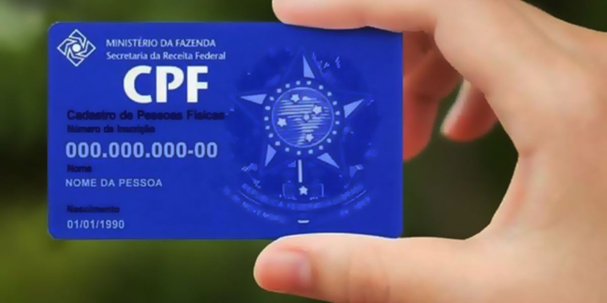 Cartão de CPF digital sendo segurado por uma mão, destacando a necessidade de verificar o status do cadastro para acessar benefícios sociais.