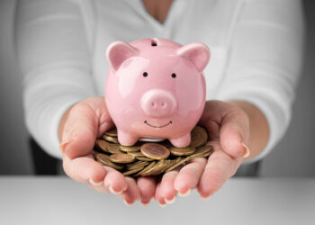 Porquinho de cerâmica com moedas, representando o ato de juntar dinheiro.