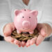 Porquinho de cerâmica com moedas, representando o ato de juntar dinheiro.
