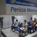 Pessoas aguardam atendimento na sala de espera da perícia médica do INSS.