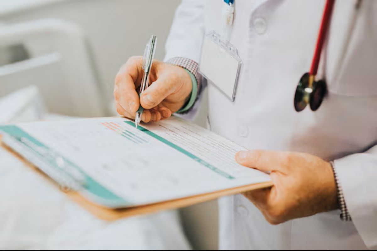 Profissional de saúde preenchendo um formulário durante uma consulta médica.