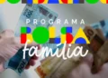 Mãos segurando cédulas de Real com logo colorido do Programa Bolsa Família sobreposto