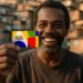 Homem sorrindo e segurando cartão do programa Bolsa Família, com uma favela ao fundo. Data de pagamento de outubro de 2025 por NIS.