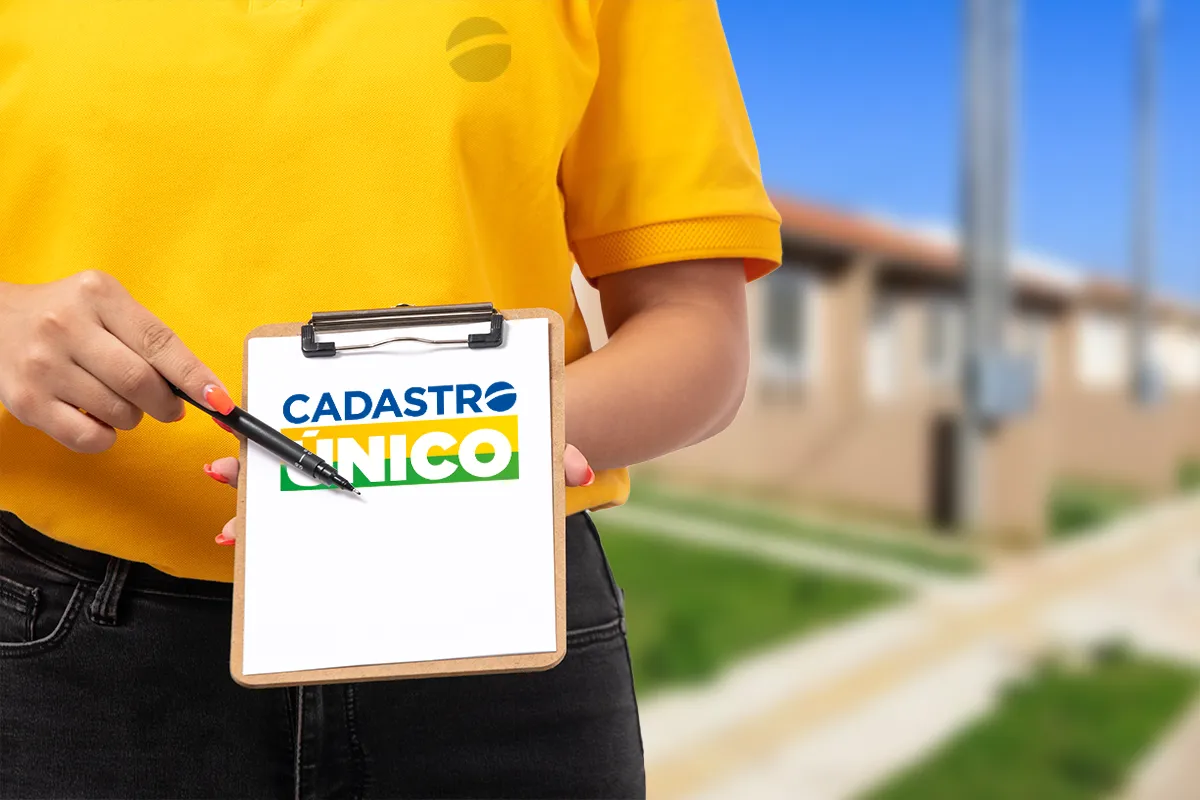 Pessoa segurando prancheta com logo do Cadastro Único em área residencial ao fundo