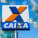 Logo da CAIXA Econômica Federal com notas de cem reais flutuando ao redor, simbolizando pagamentos e benefícios