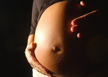 Gestante segurando a barriga durante a gravidez.