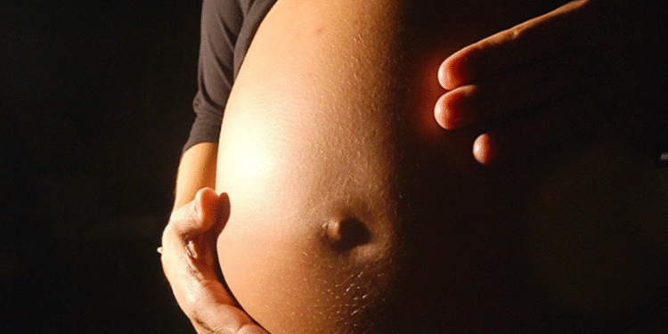 Gestante segurando a barriga durante a gravidez.