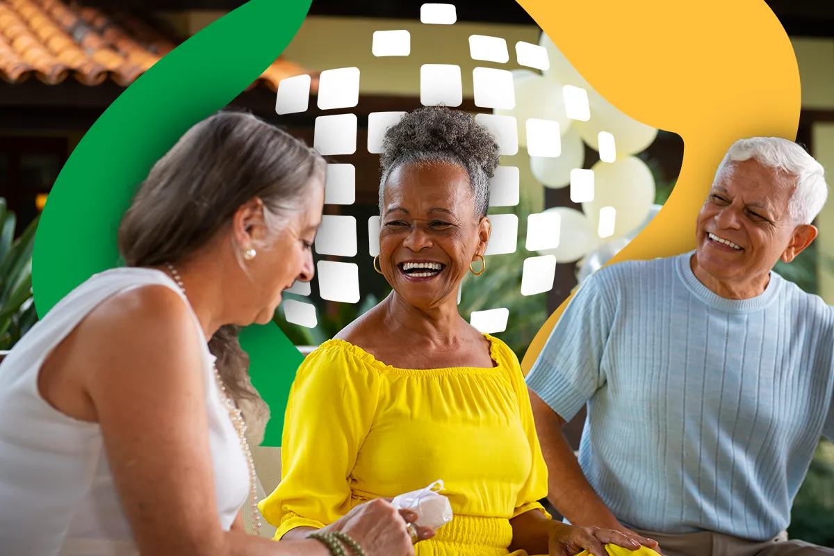 Três idosos sorrindo e conversando em ambiente externo com logo da previdência social no fundo.