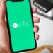 Homem segura smartphone com aplicativo Pix aberto e o logo da ferramenta, ilustrando a inovação do Pix com botão de contestação.